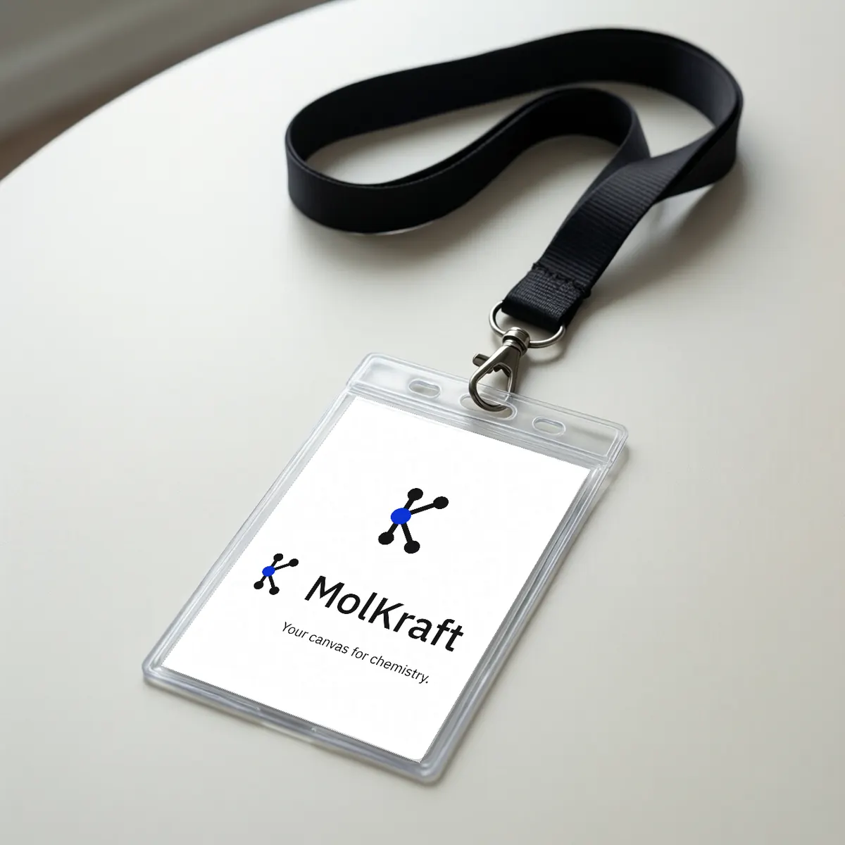 A lanyard badge with the MolKraft logo and Your canvas for chemistry.