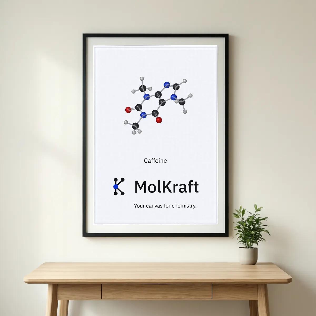 A framed MolKraft poster with a ball-and-stick caffeine molecule, the MolKraft logo and Your canvas for chemistry.