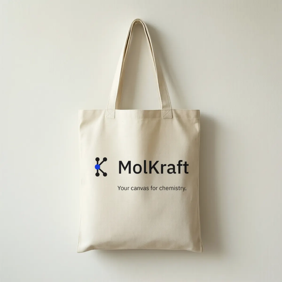 A cream canvas tote bag printed with the MolKraft logo and Your canvas for chemistry.